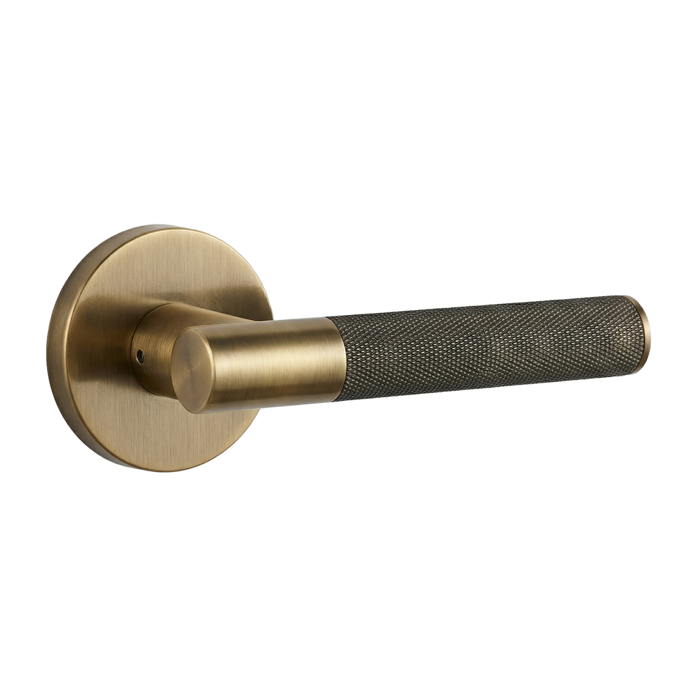 Timeless aged brass lever handle with a knurled grip, embodying quiet luxury.