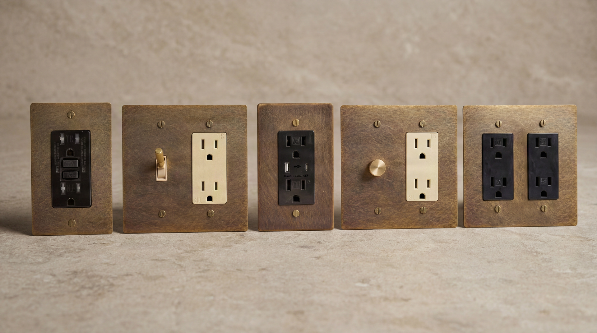 Five handcrafted Aged Brass Outlets, featuring GFCI, USB, toggle, and dimmer options in varied finishes for timeless elegance.