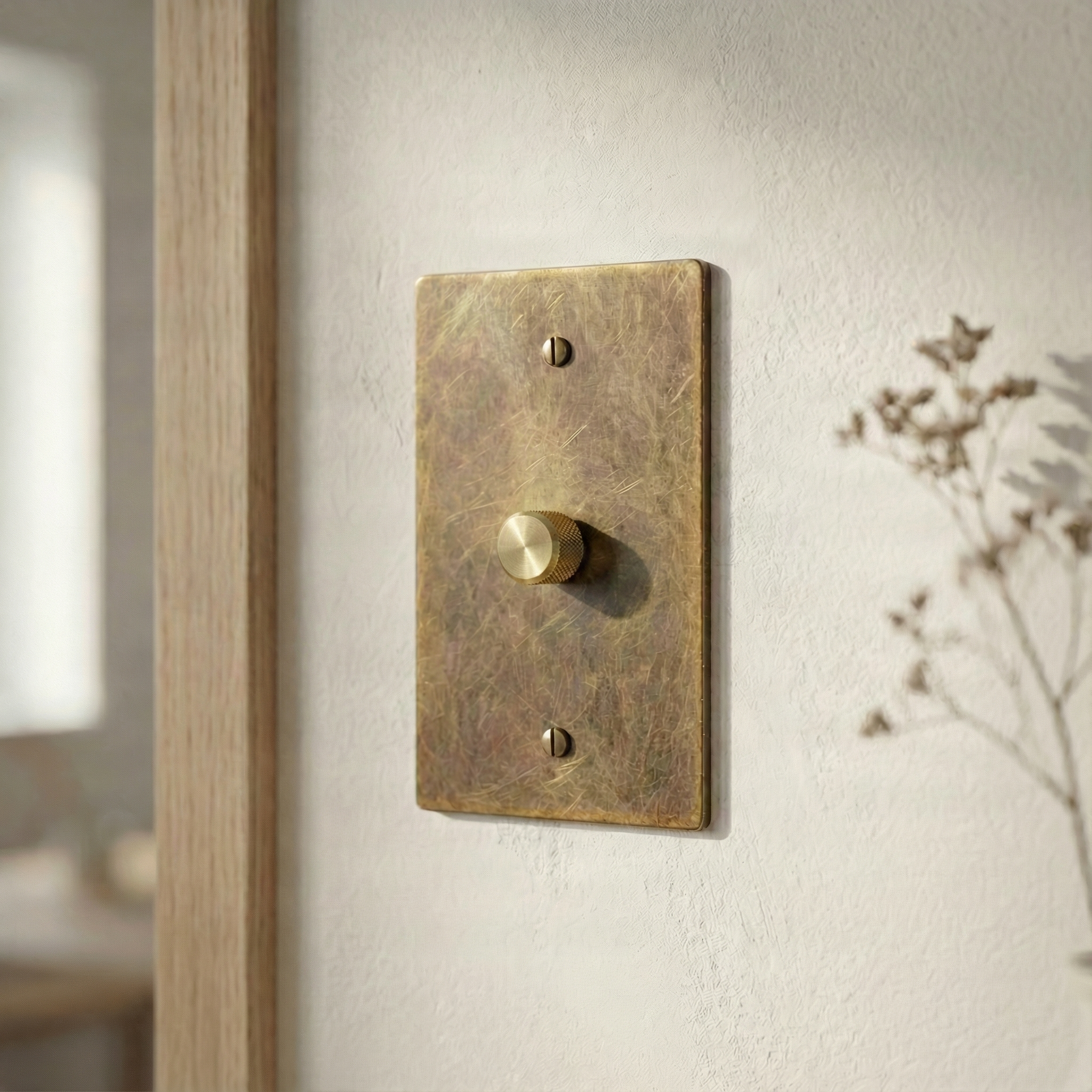 Aged brass 1 gang dimmer switch plate on a textured wall, reflecting quiet luxury and timeless design.