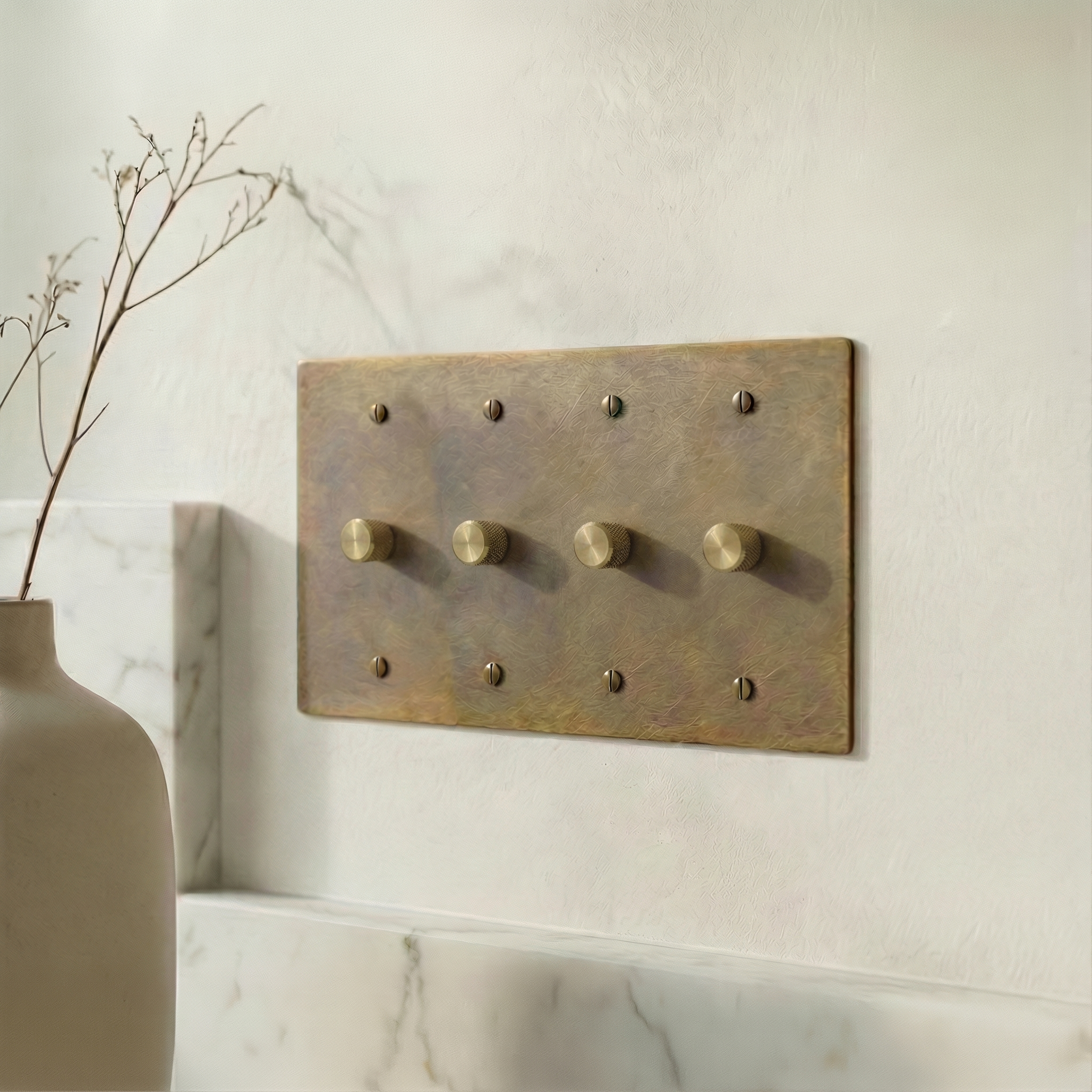 aged brass 4 gang dimmer switch plate in an elegant setting with marble and a natural vase, exuding quiet luxury.