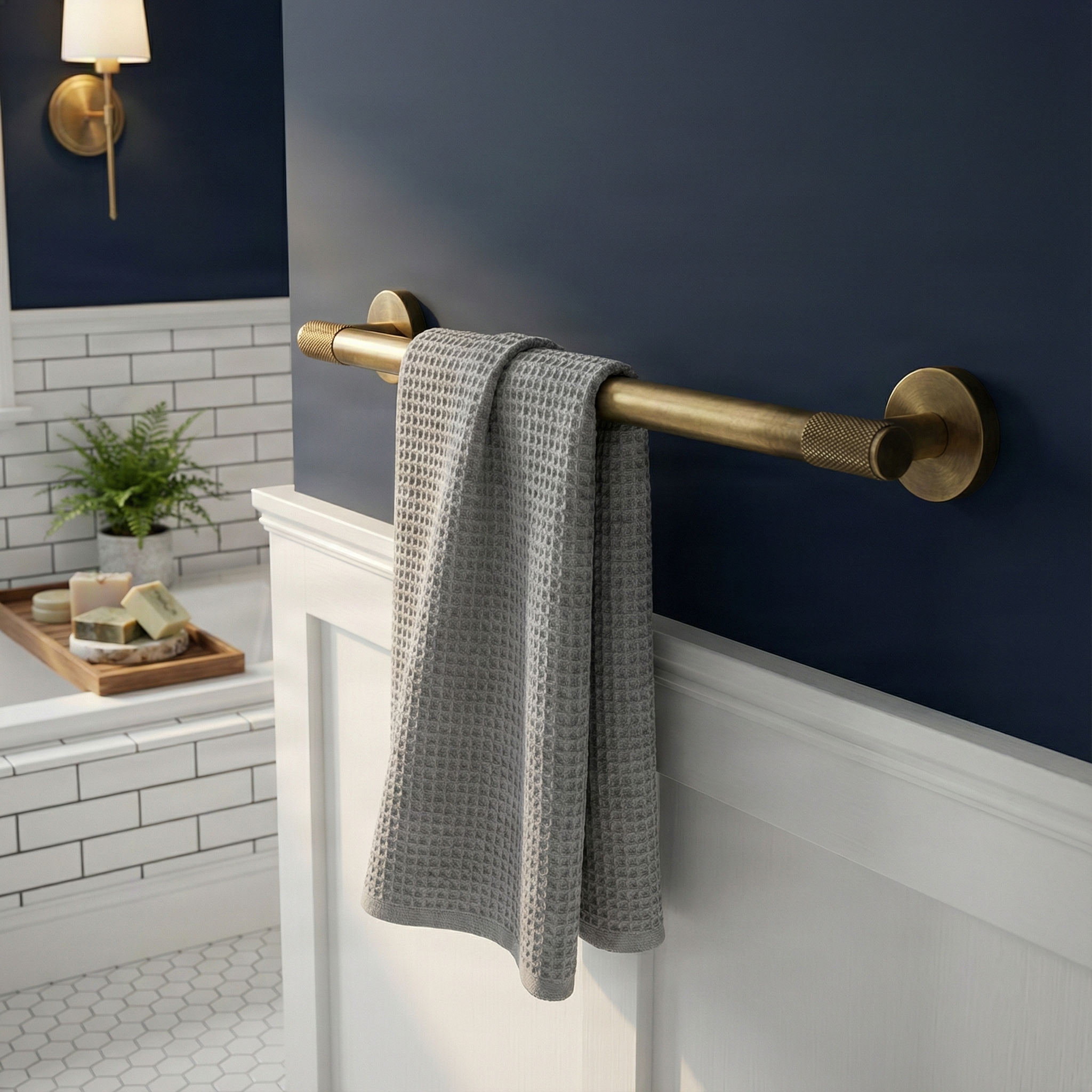 Timeless bathroom features a knurled aged brass 24 inch towel bar with a soft grey towel.