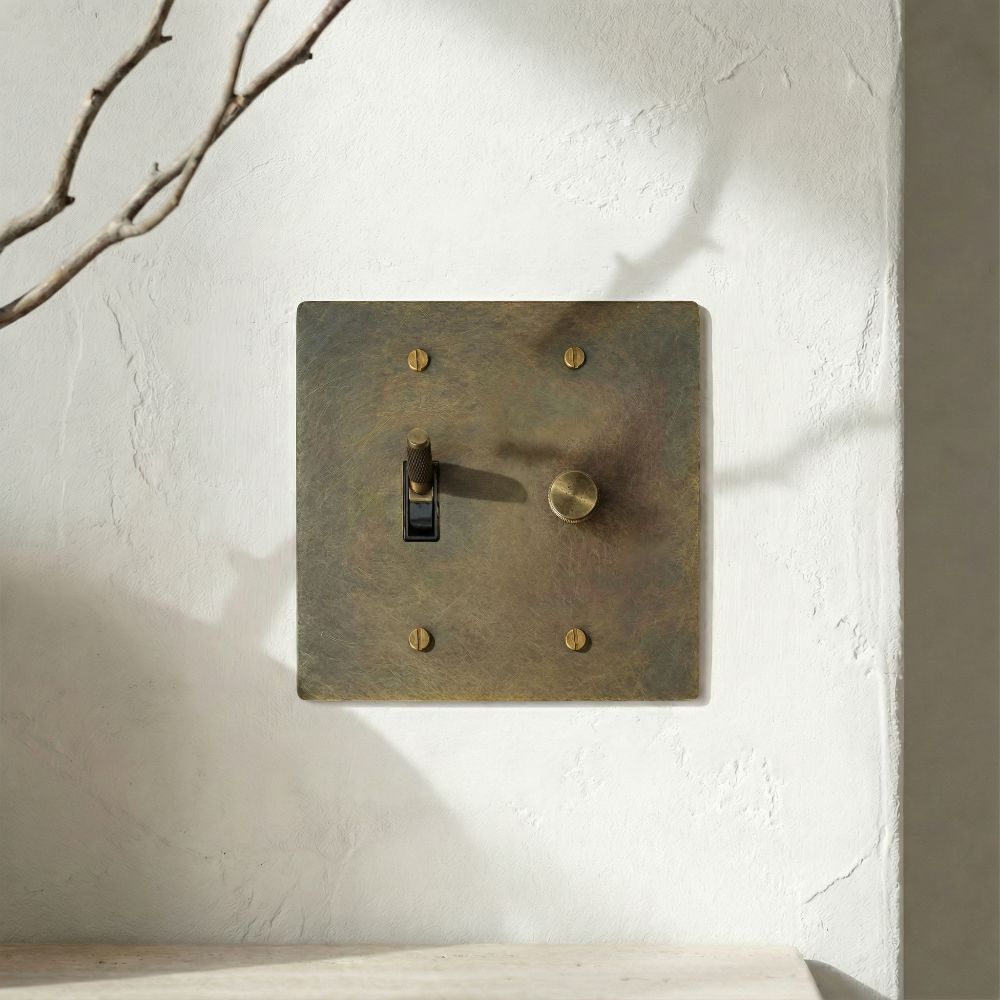 antique brass 2 gang dimmer and toggle switch plate adds quiet luxury to a minimalist wall.