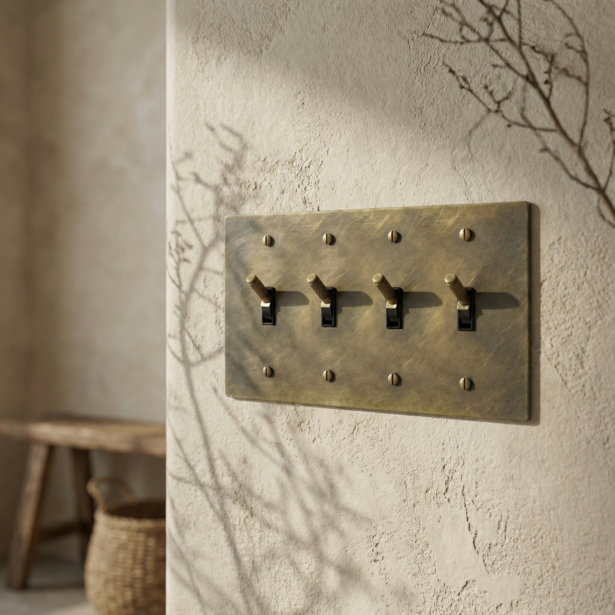 Timeless, elegant antique brass 4 gang toggle switch plate on a textured wall, soft shadows.