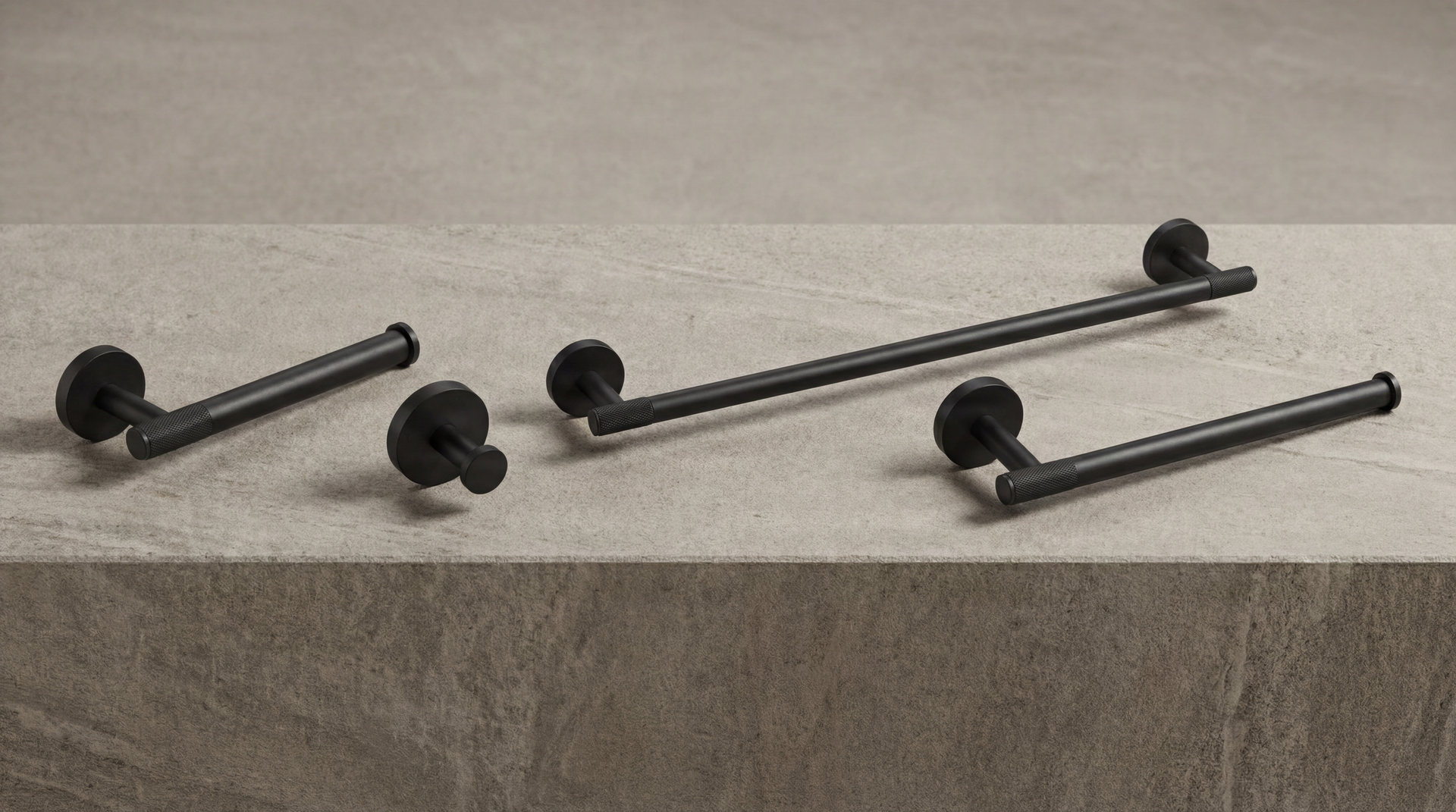 Matte Black Bathroom Hardware: solid, knurled towel bars, toilet paper holder, and hook on a textured stone surface.