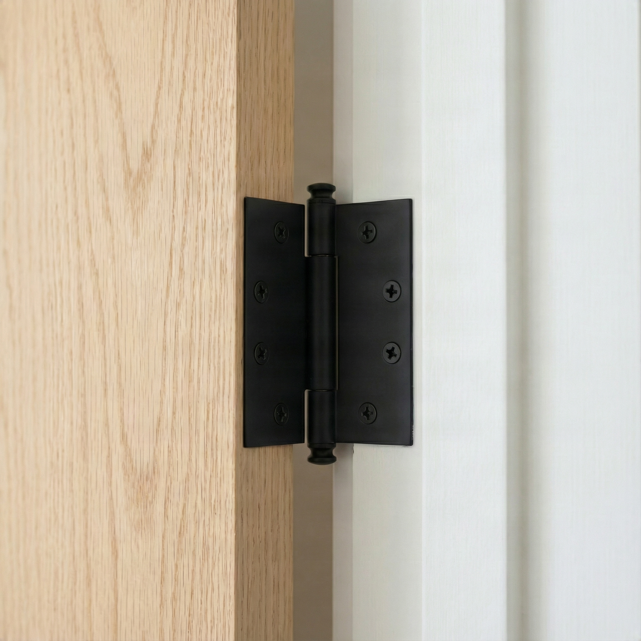 Quietly elegant brass interior hinge on warm wood and crisp white, exuding timeless design.