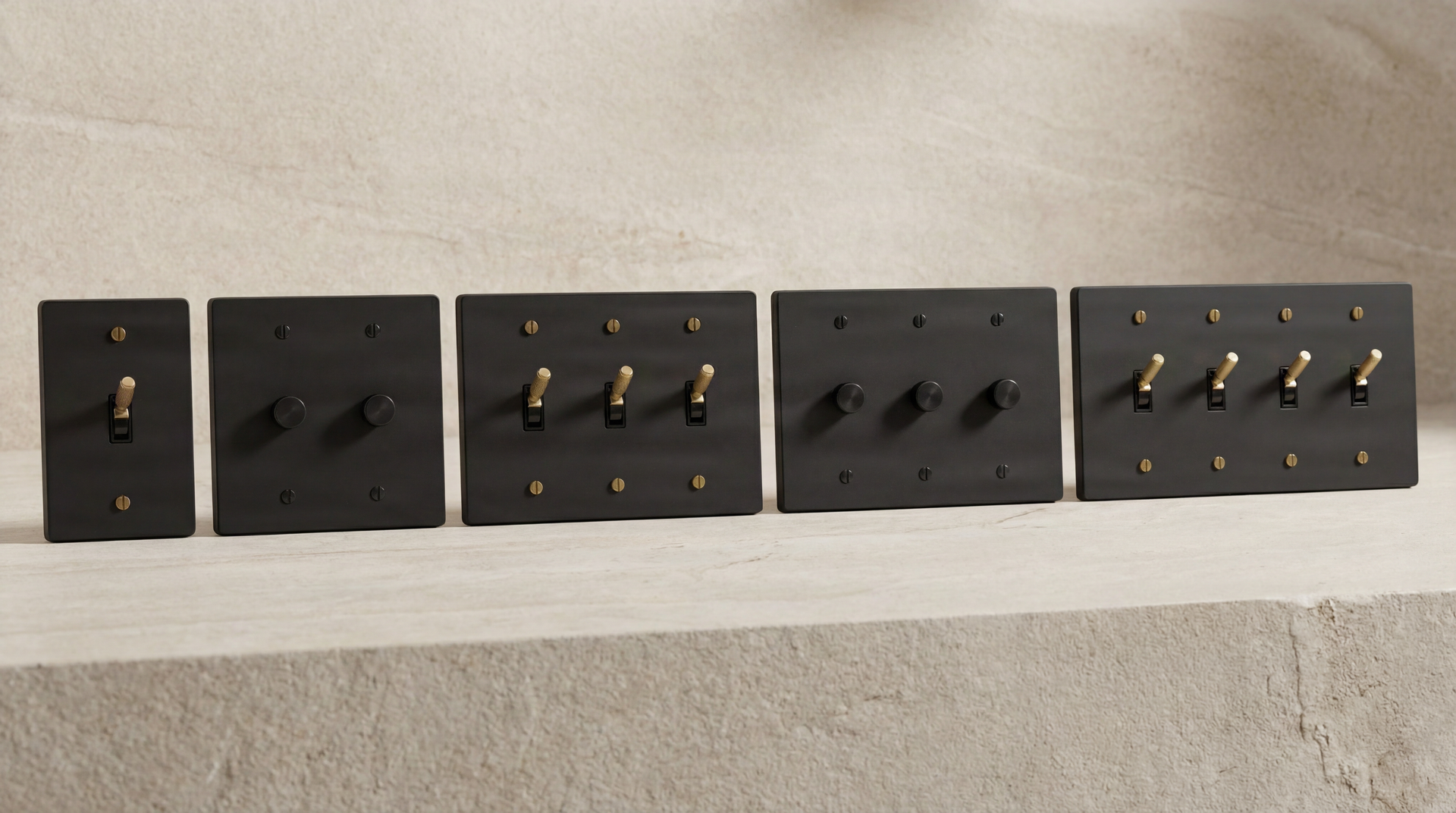 Matte Black Light Switches: Refined knurled toggles & dimmers with solid brass screws on textured stone, embodying permanence.