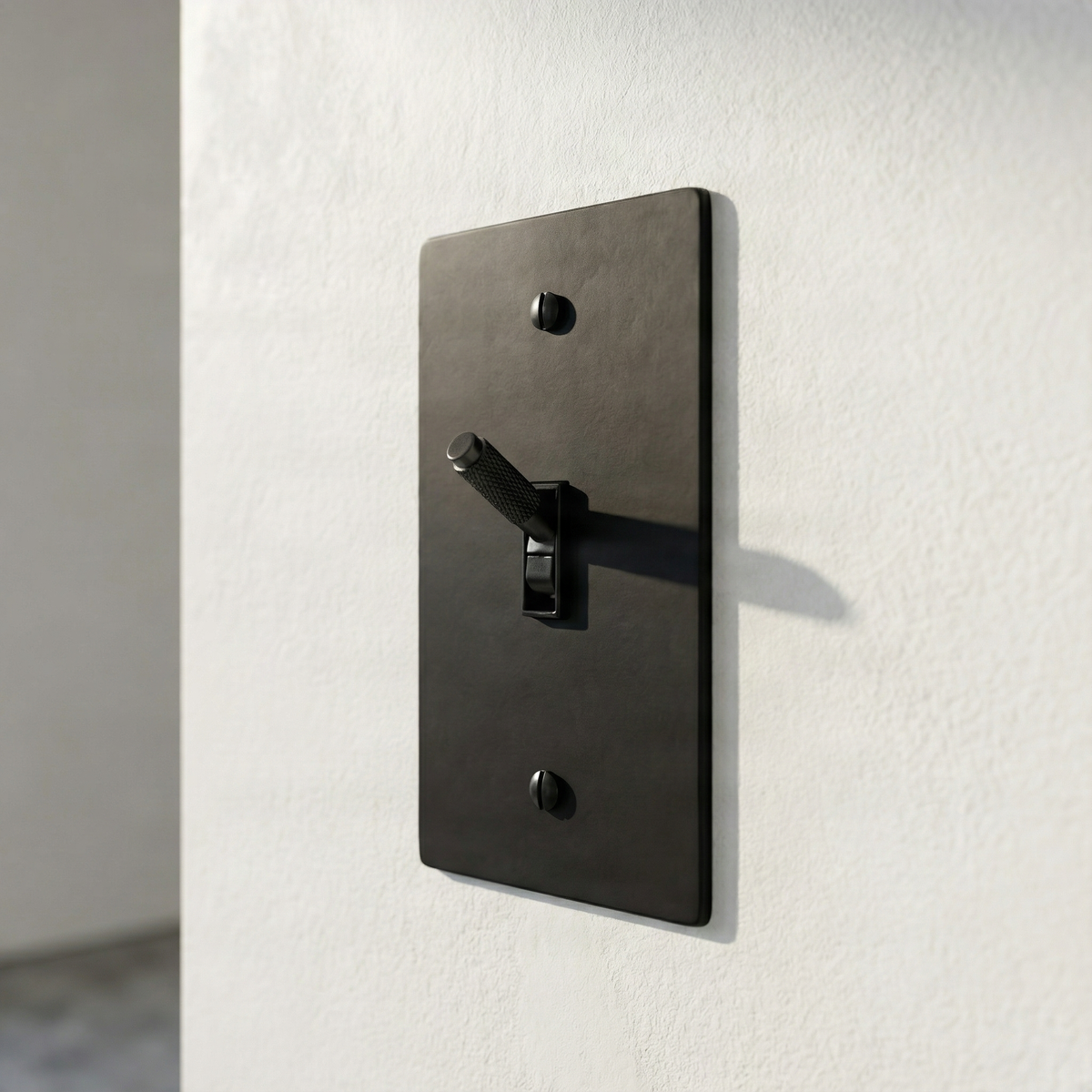 Elegant matte black (matte black accents) 1 gang toggle switch plate on a textured white wall, embodying quiet luxury.