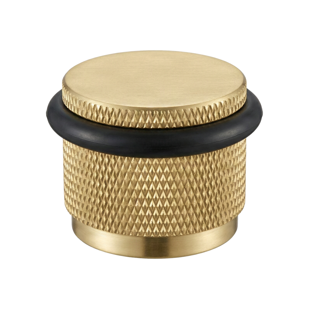 satin brass floor mount door stop with an elegant knurled texture, a symbol of enduring craftsmanship.