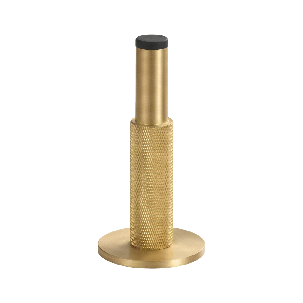 Substantial satin brass wall mount door stop with intricate knurled texture and a smooth base, signifying timeless elegance.