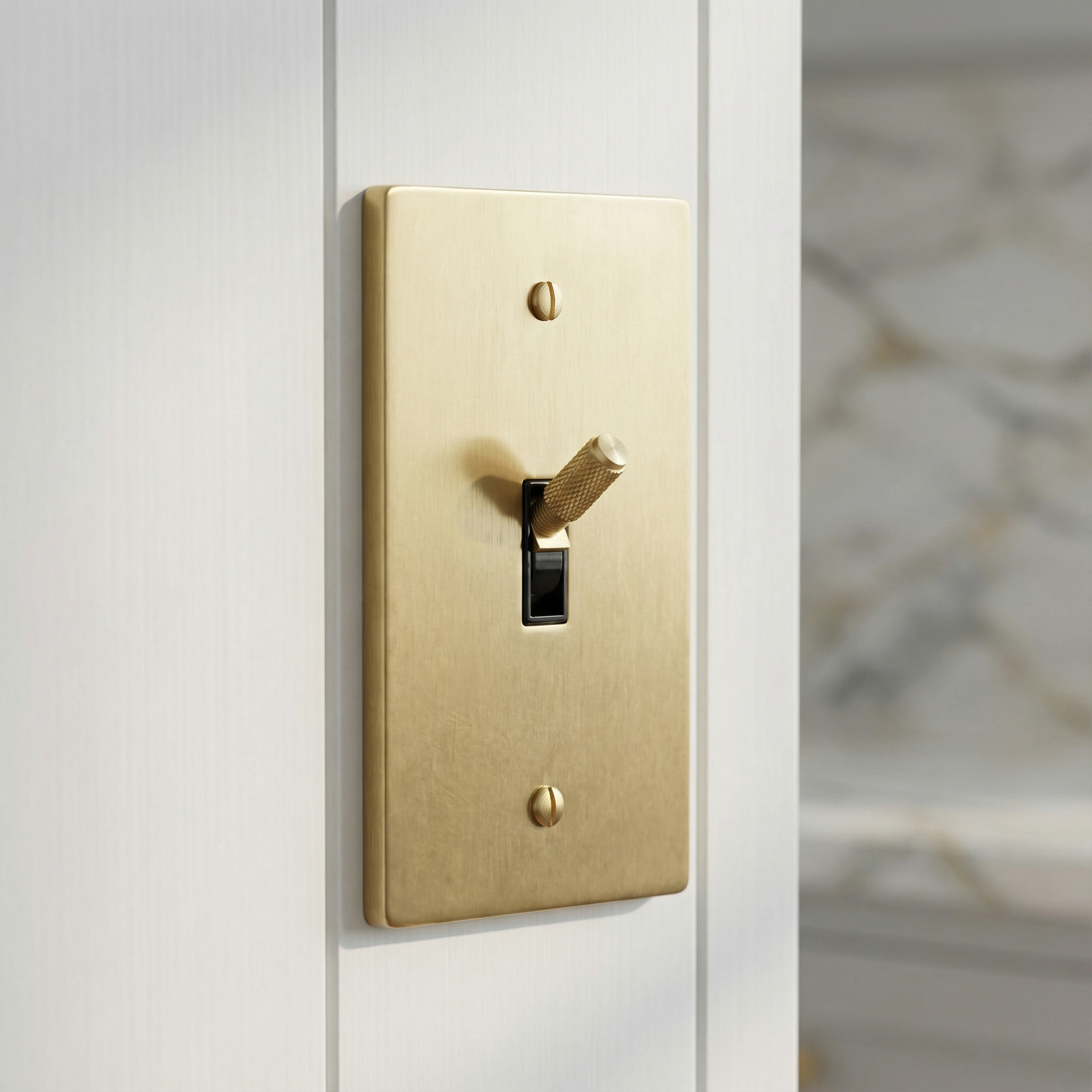 satin brass 1 gang toggle switch plate with a knurled toggle, bringing timeless elegance to a white wall.