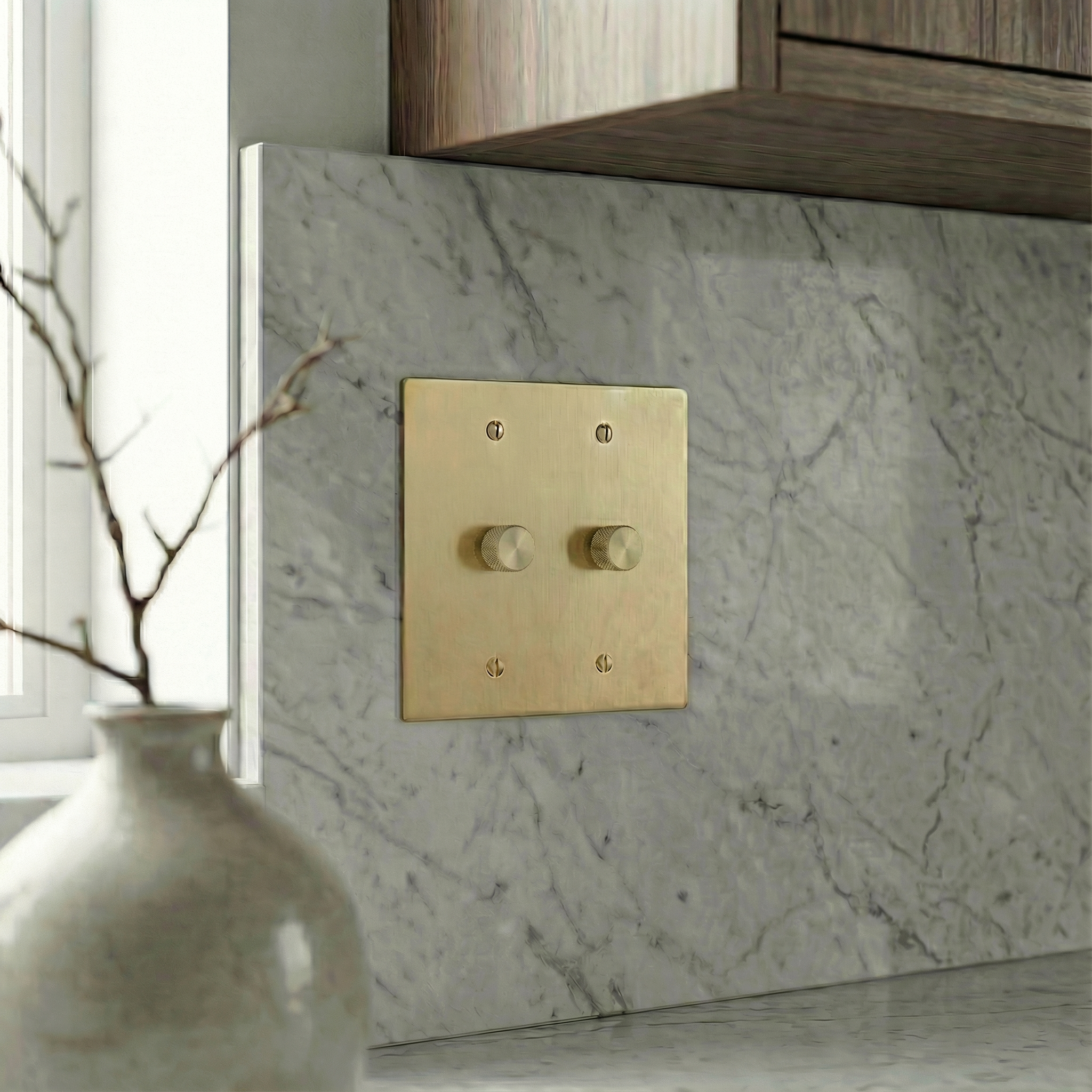 Satin brass 2 gang dimmer switch plate on a marble backsplash evokes timeless quiet luxury.