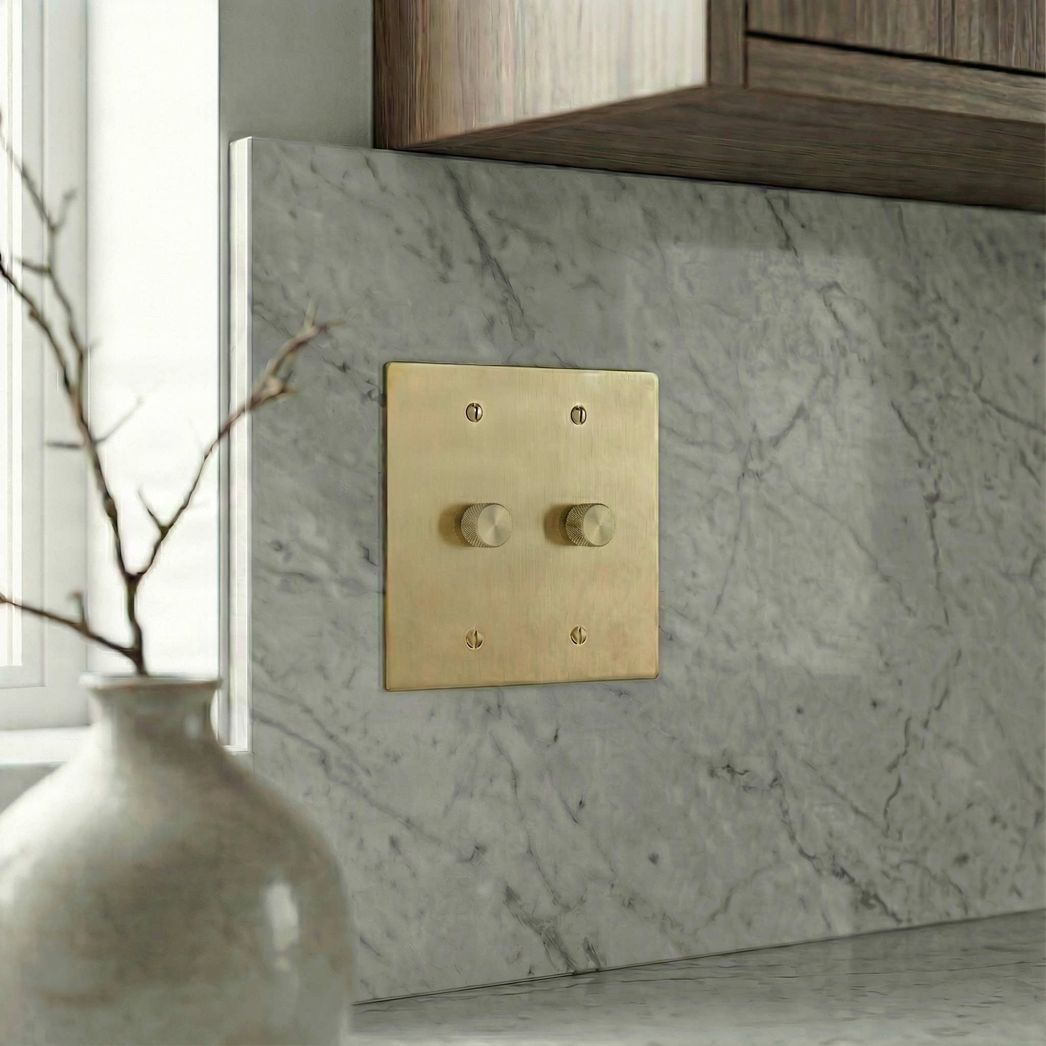 Satin brass 2 gang dimmer switch plate with knurled knobs on marble, for quiet luxury.