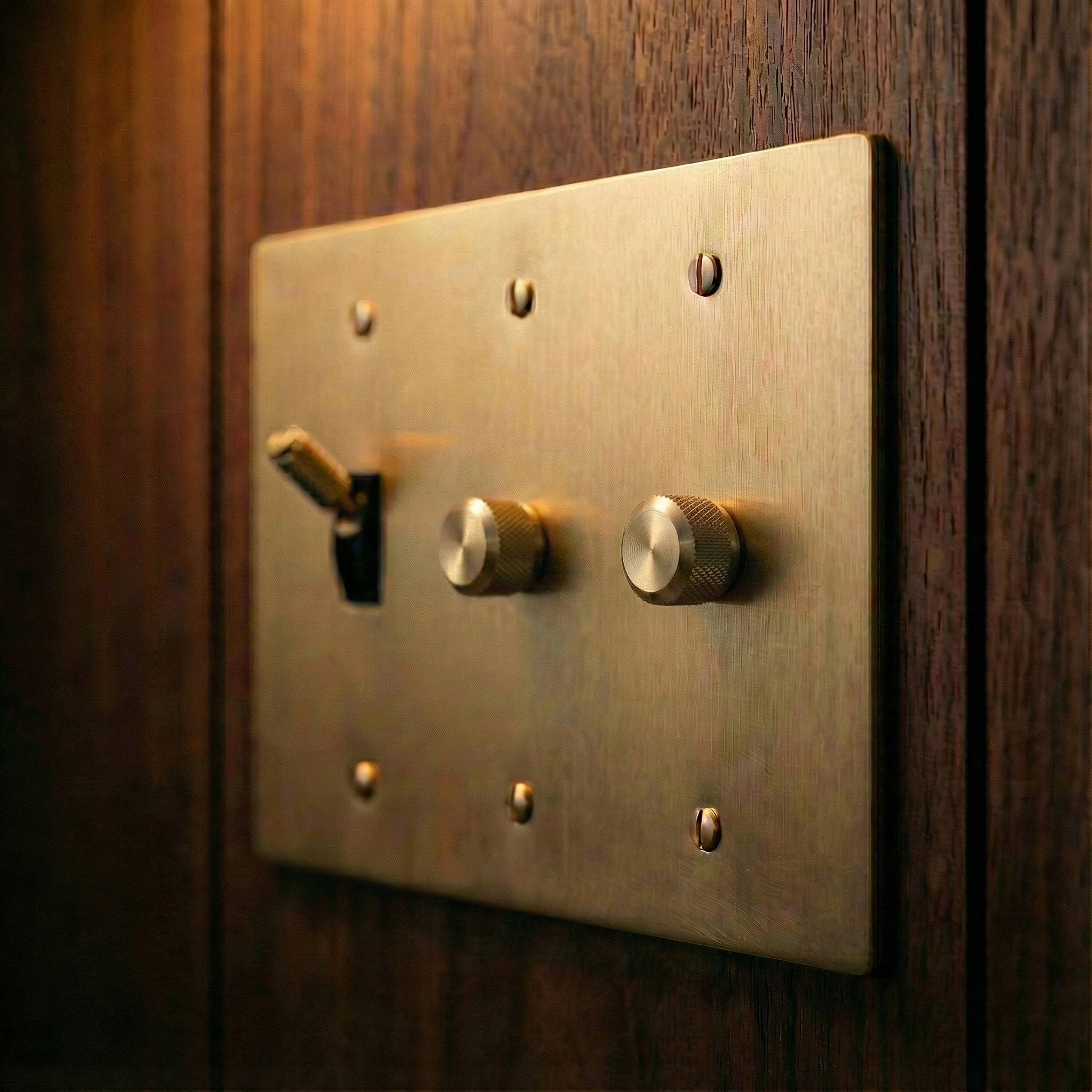 Handcrafted satin brass 3 gang dimmer and toggle switch plate on rich wood panel exudes heirloom quality.