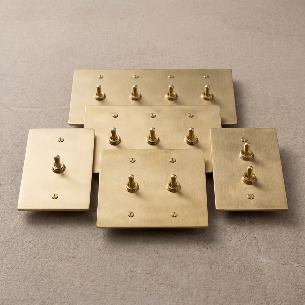 Luxe satin brass vintage toggle switches, artfully arranged.