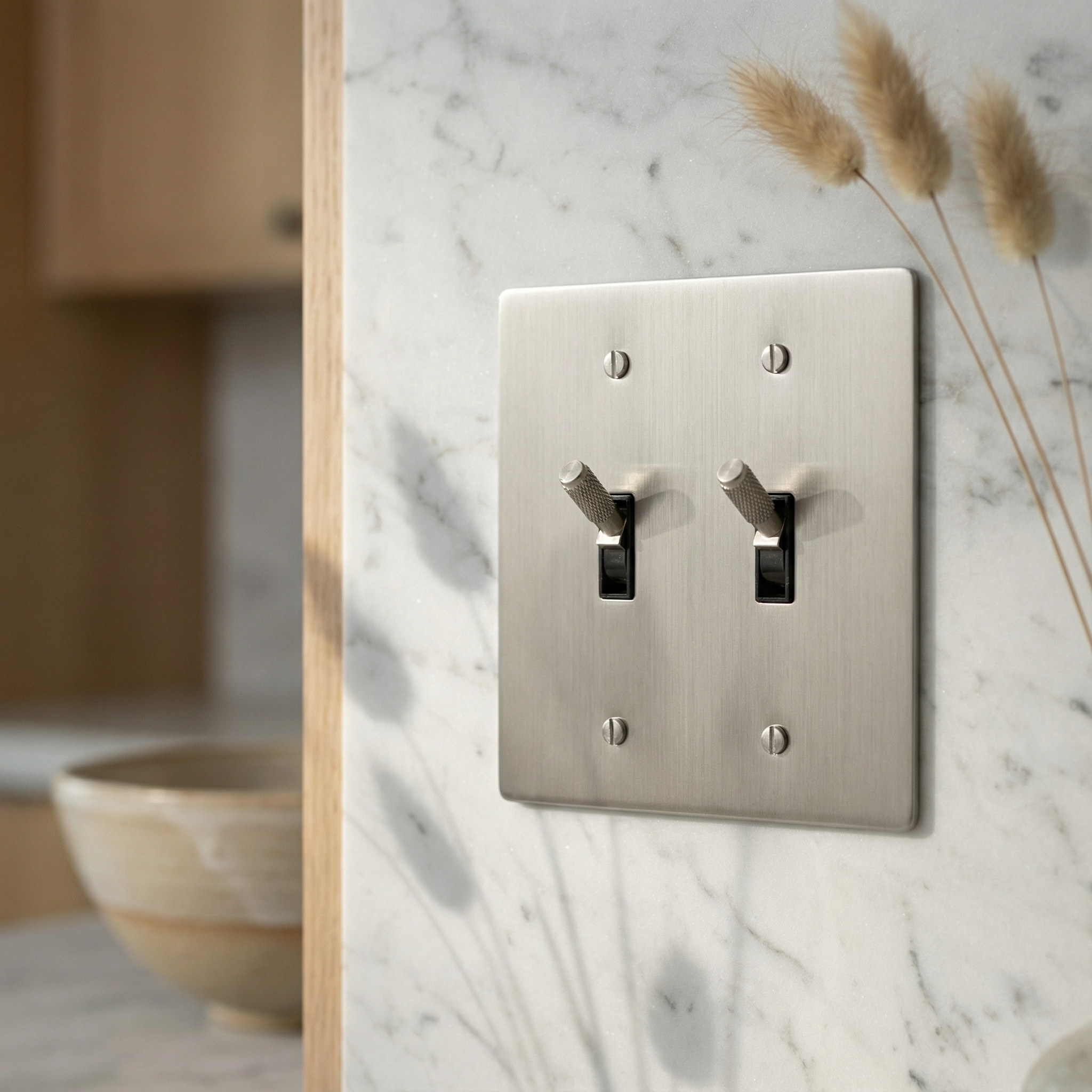 Tactile satin nickel 2 gang toggle switch plate on marble, a timeless luxury detail.