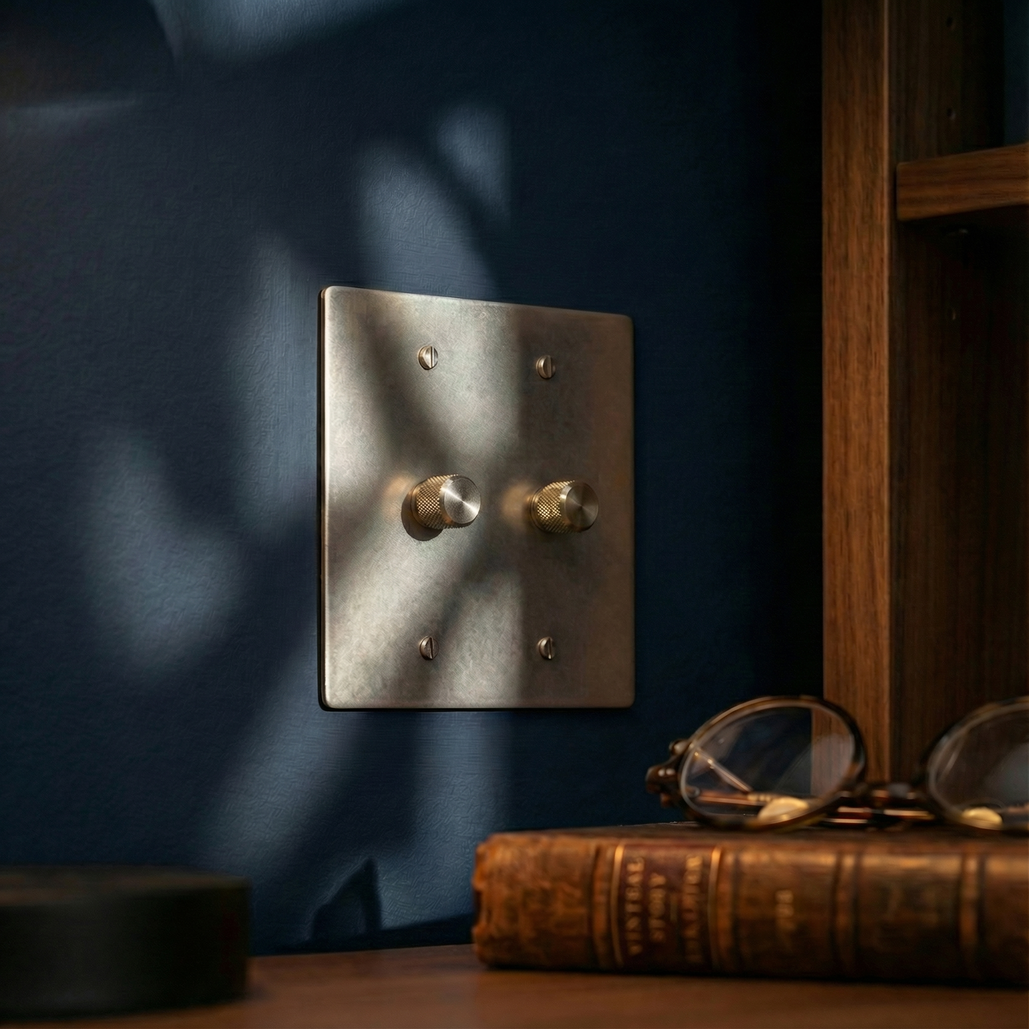 Elegant satin nickel 2 gang dimmer switch plate with knurled knobs on a navy wall, embodying timeless craftsmanship.